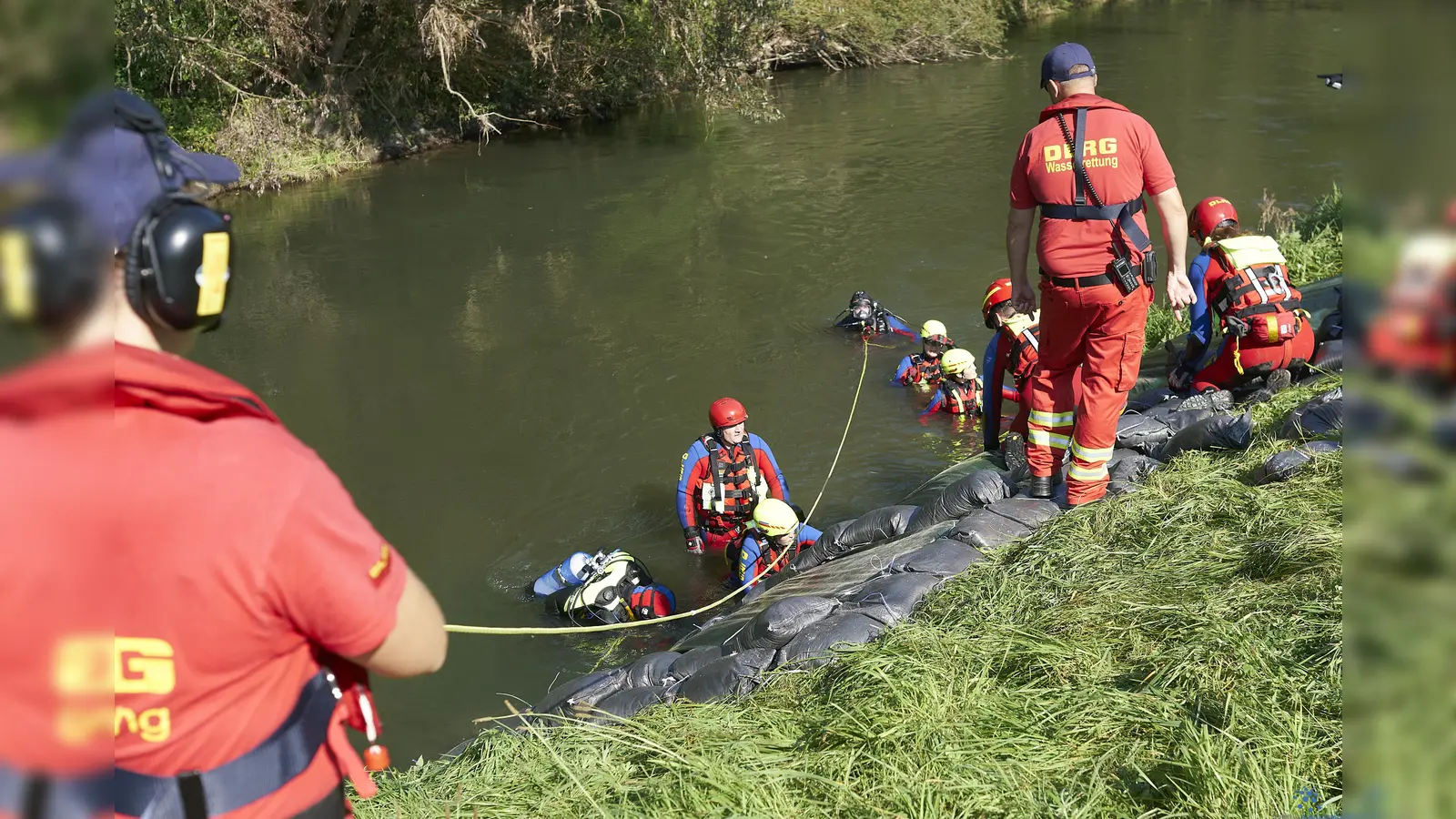 Schweisstreibende Arbeit selbst im kühlen Nass: Der Einbau von Folien und Sandsäcken zur Sicherung eines durch Hochwasser gefährdeten Deiches durch Taucher und Strömungsretter der DLRG. (Foto: Stefan Bönning)