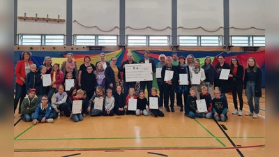 Prämienübergabe in Bodenwerder: Samtgemeindebürgermeister Sebastian Rode (in der Mitte rechts) und sein Allgemeiner Vertreter Fred Burkert (links) mit dem symbolischen Scheck über 5000 € - umringt von Kindern und Vertreter:innen der klimaengagierten Kitas und Grundschulen der Samtgemeinde, für die das Geld bestimmt ist.  (Foto: privat)