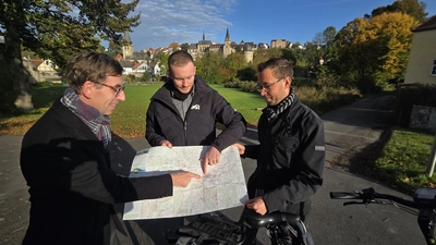 Hier liegt die Hansestadt Warburg: Bürgermeister Tobias Scherf (von links), Touristiker Lucas Lambracht und der Mobilitätsbeauftragte Jan Kolditz betrachten die neuen Tourenkarte für Radfahrer.  (Foto: Hansestadt Warburg)