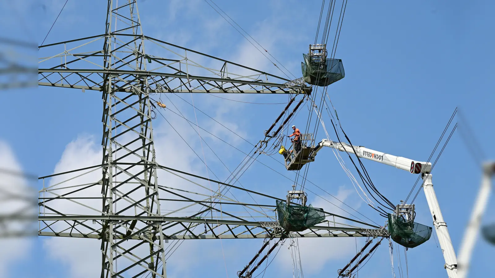 Freileitungsmonteure bei der Arbeit – hier an einem Abspannmast. Bei diesen Masten ändert sich die Richtung des Leitungsverlaufs. (Foto: UWE ZUCCHI  )